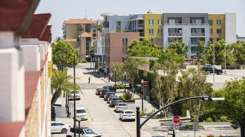 An elevated view of a street in Downey, California, with colorful buildings and street lamps