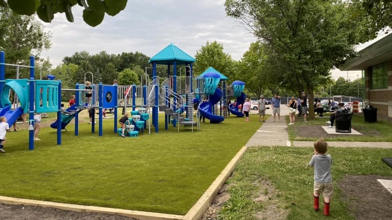blue playground structure in park with people