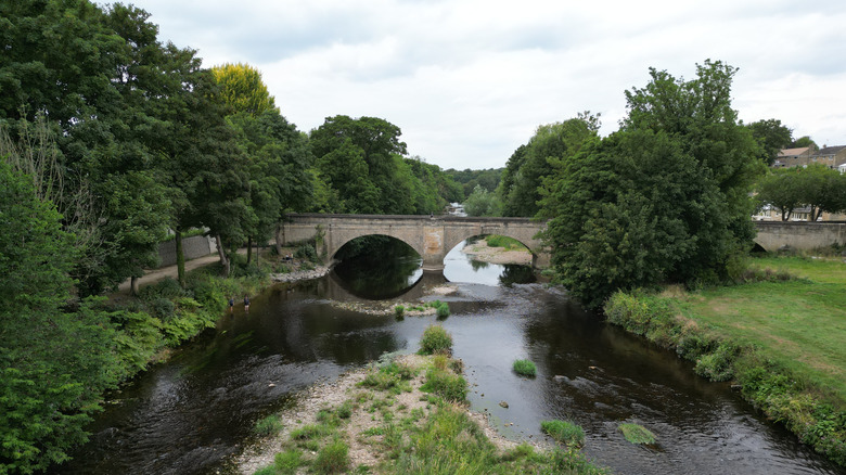 River flowing under double arched stone bridge on the River Wharfe