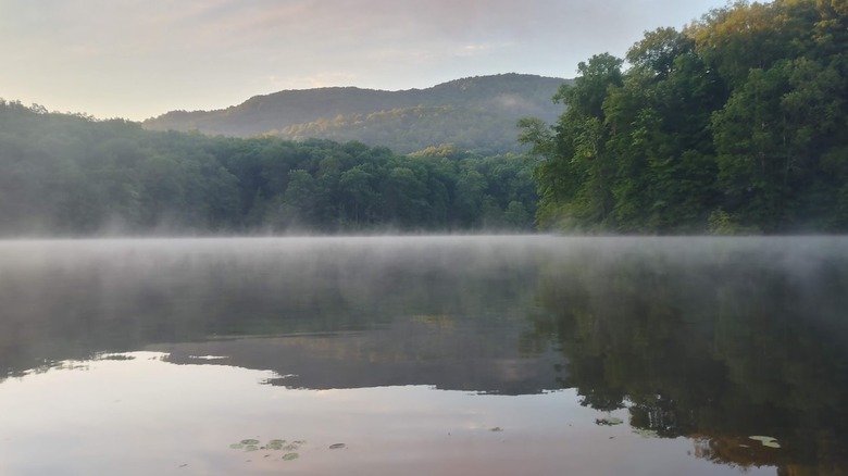 Mist over Chenoa Lake with green mountains in the background