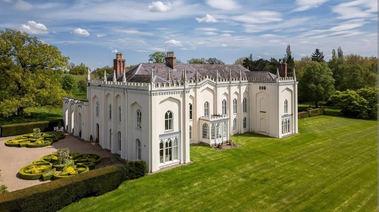 White mansion of Combermere abbey surrounded by greenery