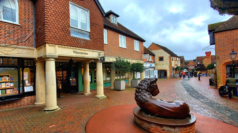 Quaint cobblestone shopping district in Farnham with lion statue