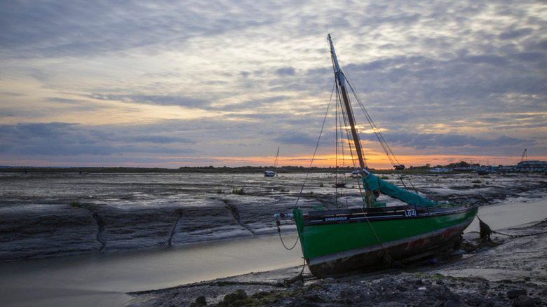 The Endeavour Cockle Boat on the shore under a darkening sky in Leigh-On-Sea