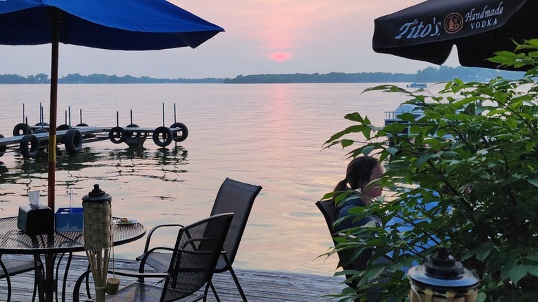 Tables on the dock at the Boathouse Pub with evening light reflecting off of Fox Lake