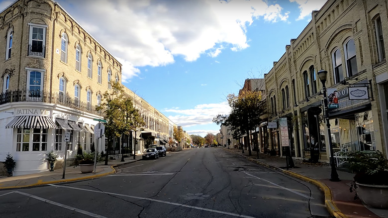 street with cars and buildings under blue sky and white clouds