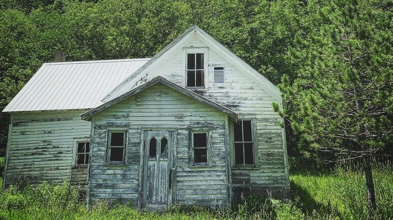Abandoned white wooden old church surrounded by trees in Avalanche, Wisconsin.
