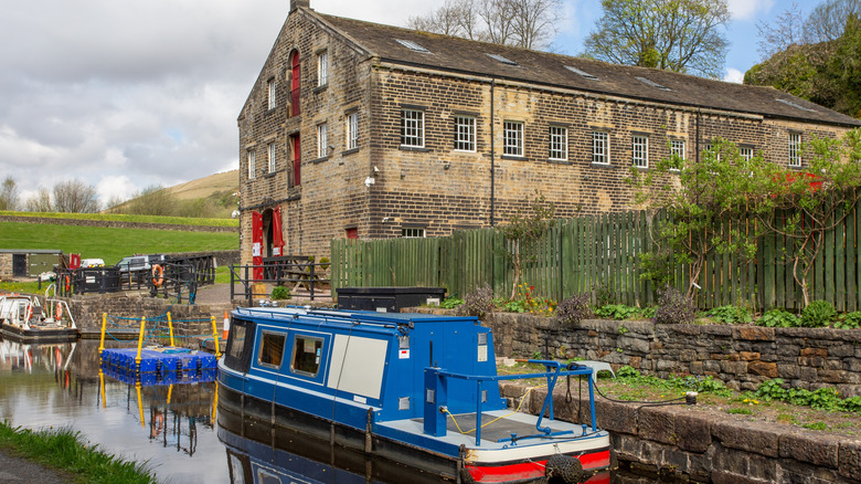 Canalside brick building with small blue barge moored