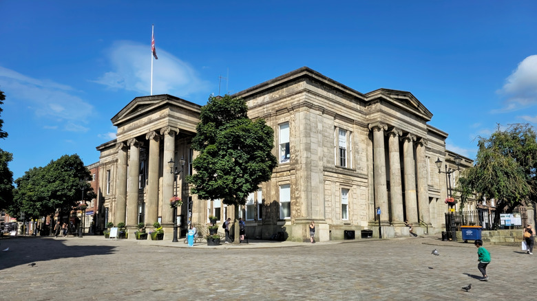 A Union Jack flag flies on top of a colonnaded town hall in Macclesfield's main square