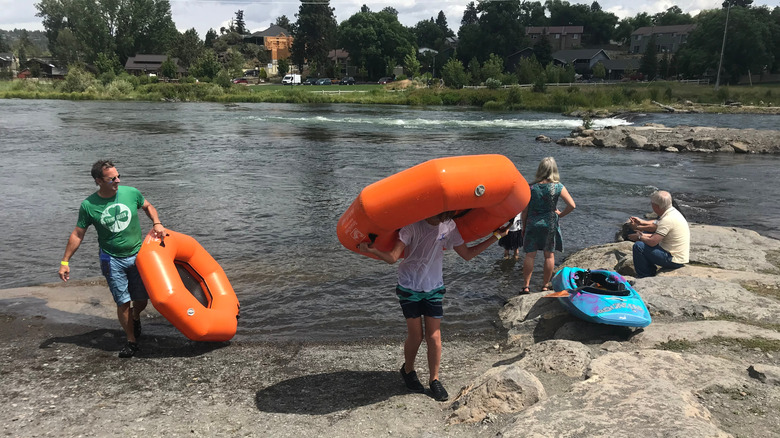 People getting off the river with their tubes on a rocky shore