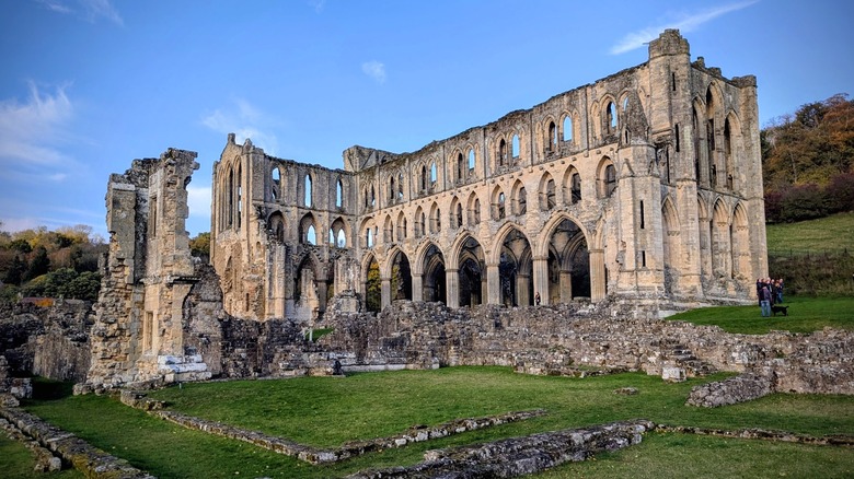The ruins of Rievaulx Abbey on a green hill