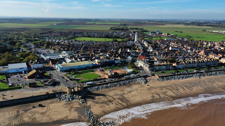 An aerial shot of Withernsea, with its beach, water, houses, promenade, and distant fields
