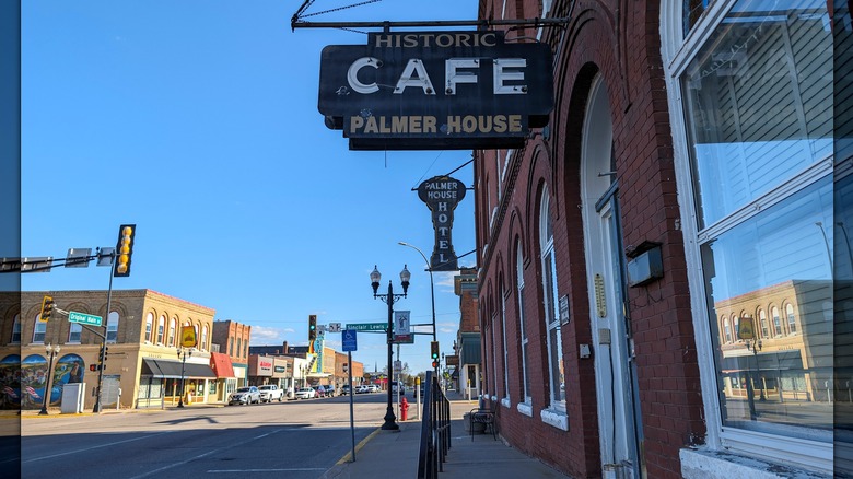 The sign of the historic Palmer House with its red-brick facade and the old-school store-lined downtown street running off into the distance