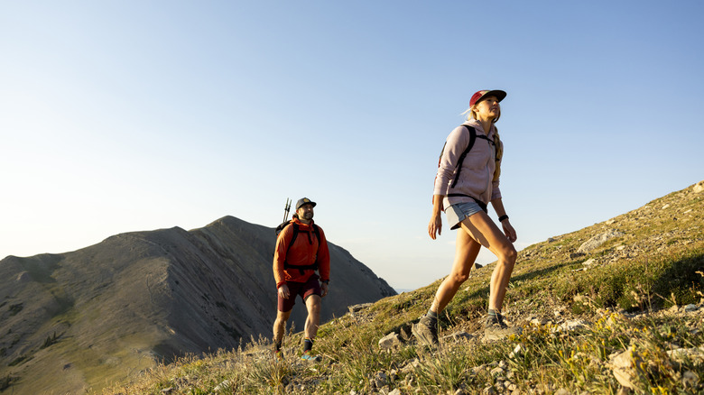 Couple hiking up mountain summit
