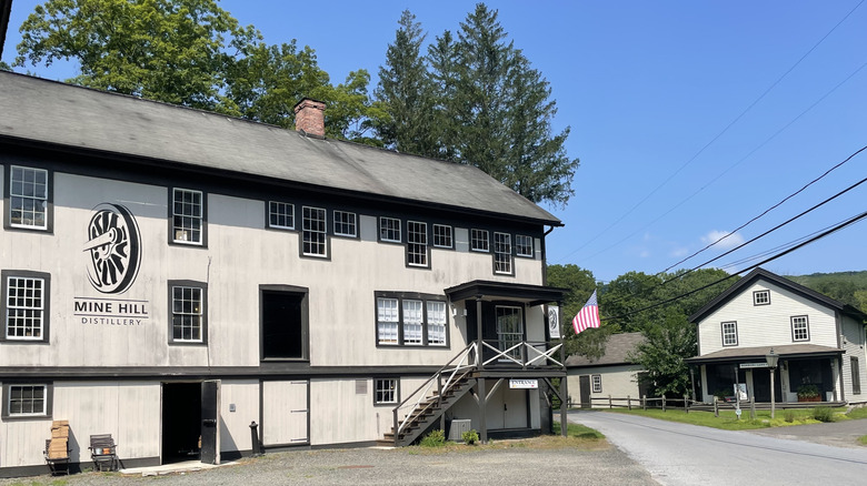 A black and white historic building labeled Mine Hill Distillery