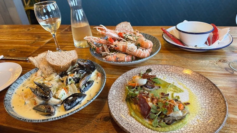 Mussels in a cream sauce, seafood salad, jumbo shrimp, and a glass and pitcher of white wine at The Fish Shack