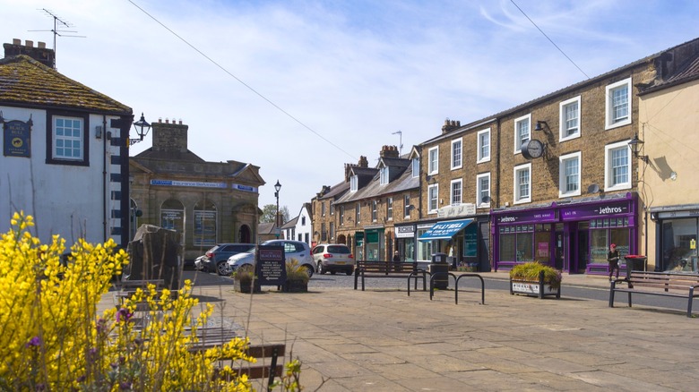 A road lined with colorful shops and stone buildings on a cloudy day in Haltwhistle, Northumberland, England