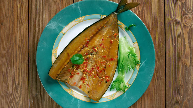 Salted herring -- known as Craster kippers -- on a turquoise plate on a wooden table