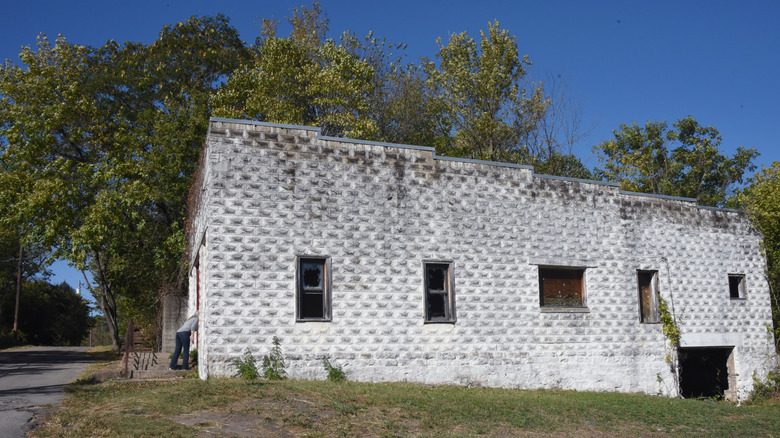 Visitor peeks in the window of the former funeral home of Pepper Sauce Alley, a ghost town within the town of Calico Rock, Arkansas