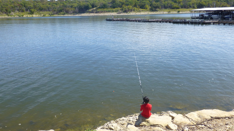 A boy fishing from shore at Eishenhower State Park on Lake Texoma