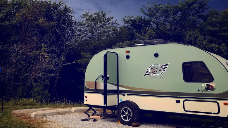 An RV camper with trees and dark sky in the background at at Duck Creek Recreation Area.