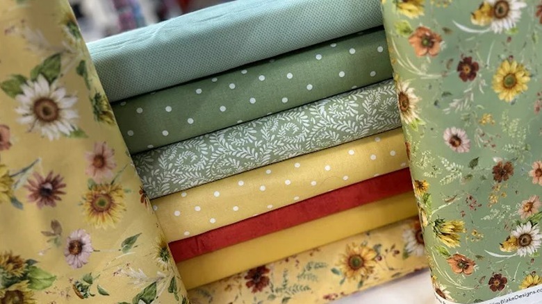 Stacked materials for quilts in different colors and textures at Sarah Kathryn's Quilts.