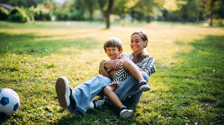 Mother and son play together in park