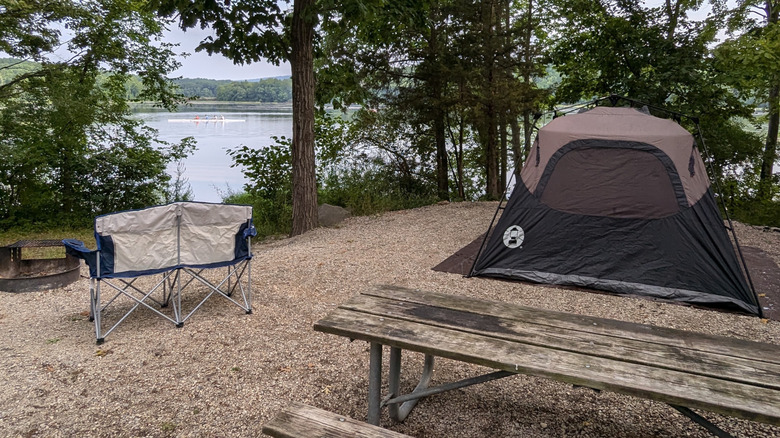 Campsite in Gifford Pinchot State Park, with a gray tent and wooden picnic table with lake views