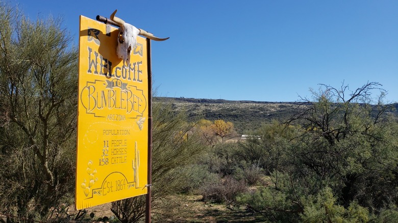 A yellow Bumble Bee sign with a cow skull and blue sky in the background