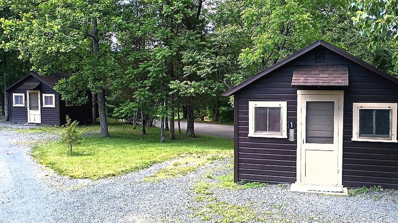 Little camping cottages surrounded by trees and gravel paths in Little Buffalo State Park campground.
