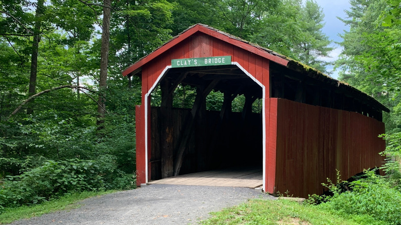 The historic Clay's Covered Bridge along one of the pathways surrounded by trees in Little Buffalo State Park.