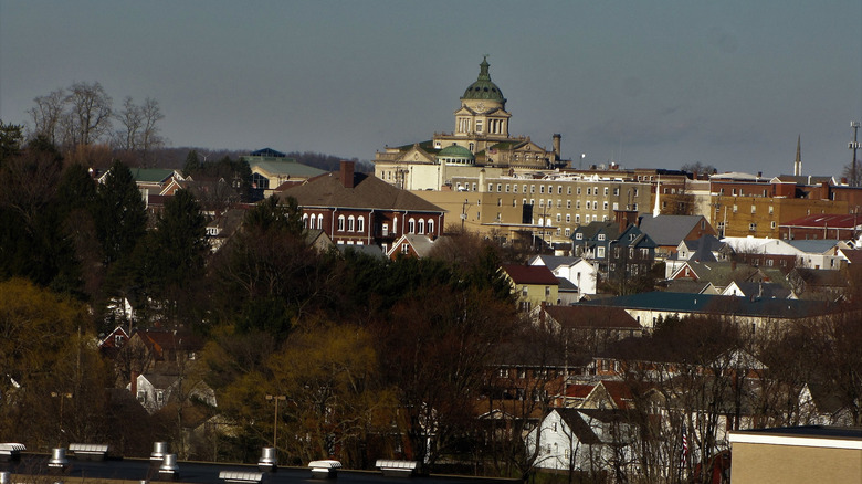 View of Somserset, Pennsylvania, with a green-domed buidling rising above homes and other structures, surrounded by winter trees under a blue sky