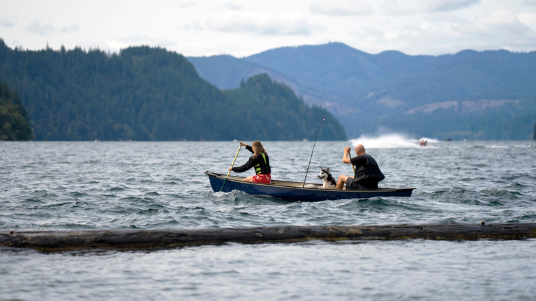 People paddling a canoe on Lake Merwin with their dog and fishing pole