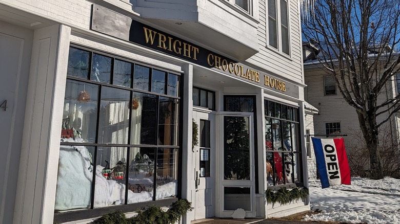 The white wooden façade of Wright Chocolate House on a snowy day in Limerick, Maine