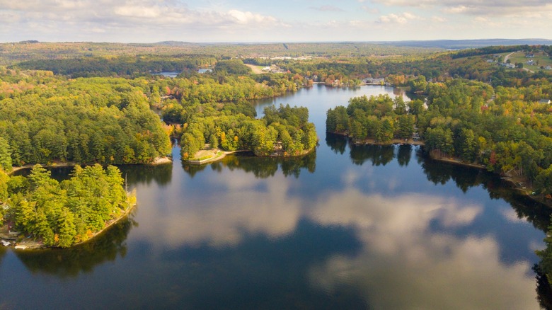 An aerial view of fall foliage and Sokokis Lake reflecting clouds in Limerick, Maine