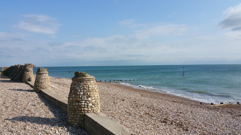 Beach in Selsey with a stone wall adorned with rounded stone posts