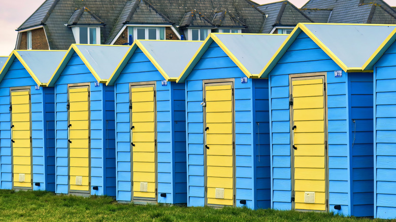 Row of bright blue and yellow beach huts in Felpham