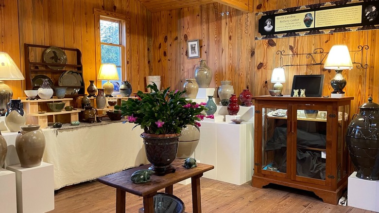 Display of vases and pottery in wood-paneled room Jugtown Pottery Seagrove North Carolina