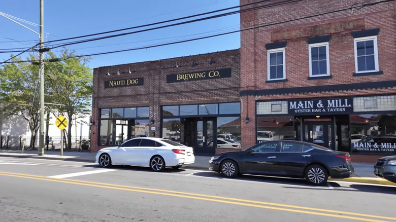People in a green field amid carnival rides during the Winterville Watermelon Festival in North Carolina