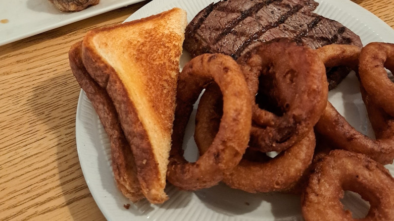Plate of steak, fried onion rings and greens at Peggy's Kitchen