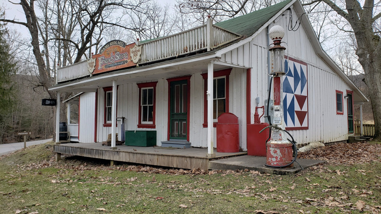 A vintage store sits on the grounds of a park in the middle of a forest.