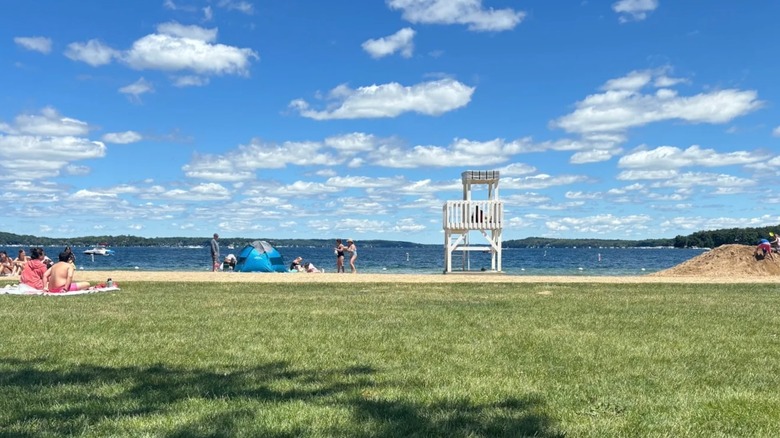 A view of the lifeguard stand on Fontana Beach and Geneva Lake from the shaded grassy park area