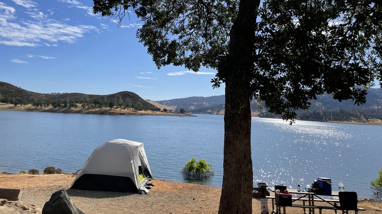 White tent looks over shimmering surface New Hogan Lake in California from idyllic spot