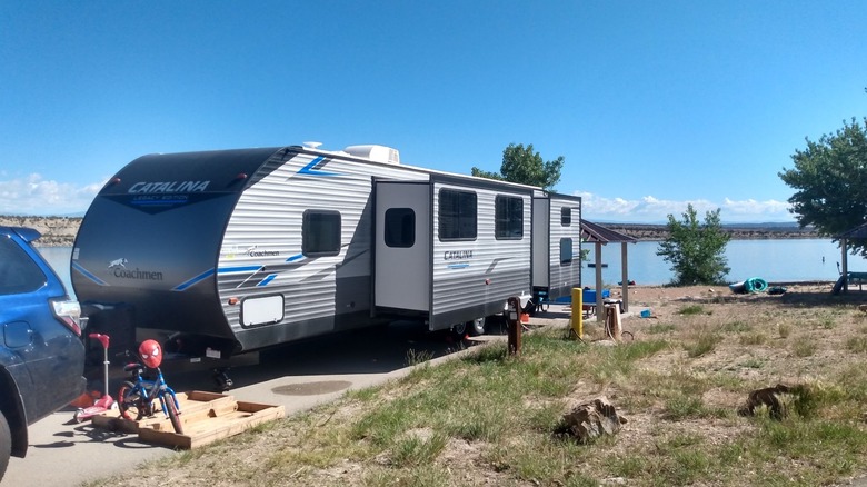 A car with a long trailer parked at a lakefront campsite at Fred Hayes State Park at Starvation.