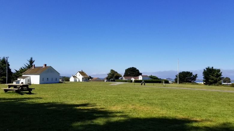 A trimmed lawn on a bluff dotted with historic buildings at Fort Humboldt Historic State Park, in California.