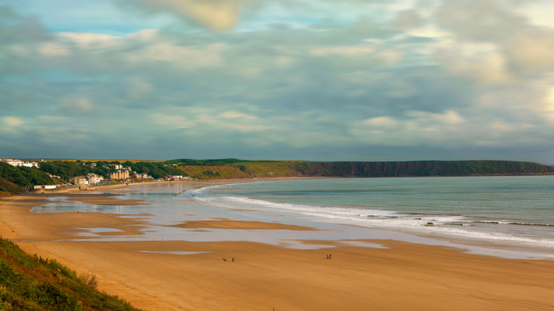 Filey's long and wide sandy beach fringed by houses and hills in the distance