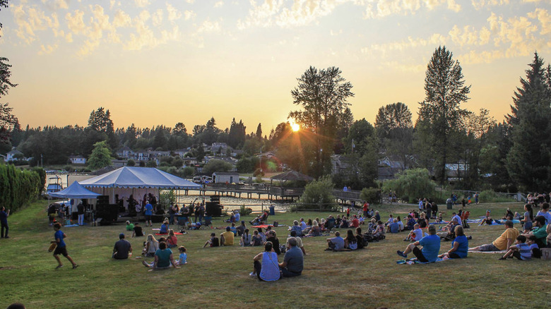 People sitting and enjoying a live performance in North Cove Park at sunset in Lake Stevens, WA