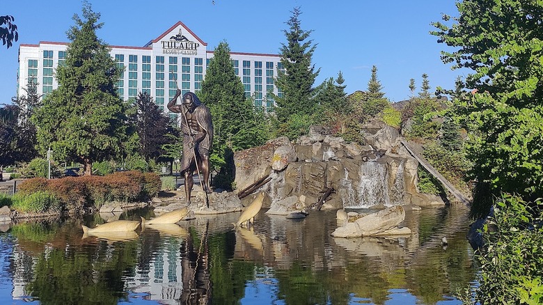Fountain pond with a brass sculpture of a Native American man fishing outside the Tulalip Casino Resort