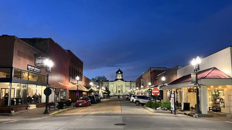 Downtown Jackson, Missouri, at nightfall with streetlights shining on old brick buildings and the courthouse at the end of the street
