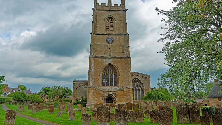 The tower of St Peter's Church stands above its historic gravestones.