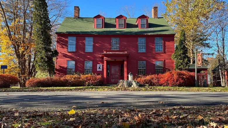 An old, red house with a green roof, the oldest building in Deposit in Delaware County, New York